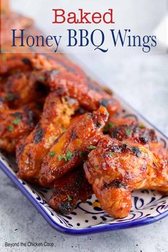 baked honey bbq wings on a blue and white plate with the title above it