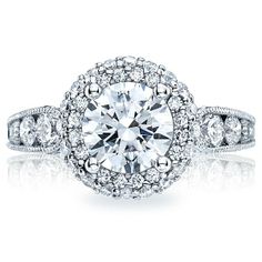 an engagement ring with diamonds on the sides and a halo setting in the middle, surrounded by round brilliant pave stones