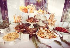 an assortment of desserts and snacks on a table with utensils in bowls