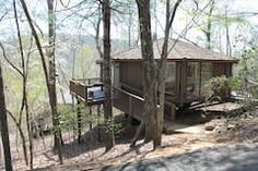 there is a small cabin in the middle of the woods with stairs leading up to it