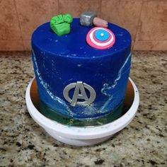 a blue cake with captain america decorations on it