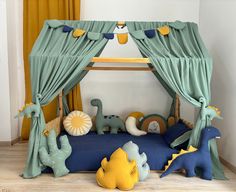 a child's bed with green drapes and blue bedspread, stuffed animals on the floor