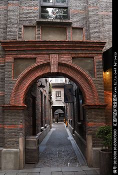 an arched brick building with a clock on it's side