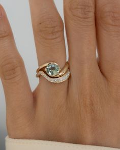 a woman's hand with a gold ring and an aqua blue stone on it