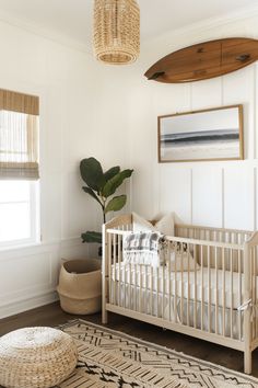 a baby's room with a surfboard hanging above the crib and rug on the floor