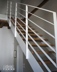 there is a white stair case with wooden handrails