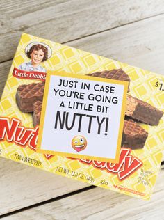 a box of nutty bars on top of a white wooden table with a sign that says, just in case you're going a little bit nutty