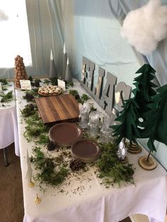 the table is set up with pine cones and cookies