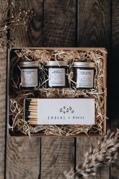 an open box with three candles and matches in it on top of a wooden table