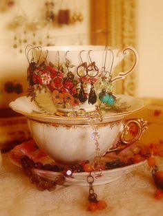 there is a tea cup that has been decorated with jewelry