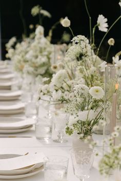 a long table with white flowers and place settings