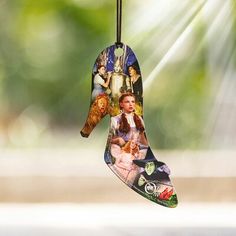 an ornament hanging from a string with pictures on it's side,