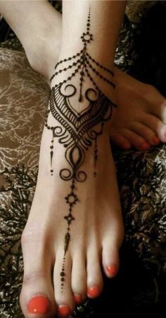 a woman's foot with a henna tattoo on it