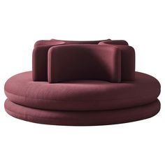 the circular sofa has two pillows on it and is made out of red fabric,