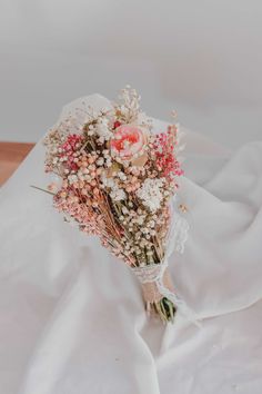 a bouquet of flowers sitting on top of a white sheet