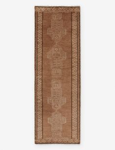 a brown rug with an intricate design on the front and back side, hanging from a wall