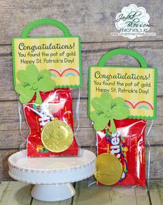 two bags with gold coins in them sitting on top of a white cake plate next to each other