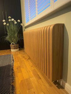 a wooden radiator sitting on top of a hard wood floor next to a window