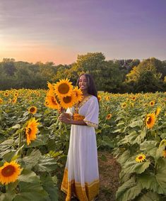 a woman standing in a field of sunflowers