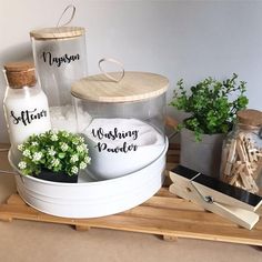 three jars with names on them are sitting on a shelf next to plants and other items