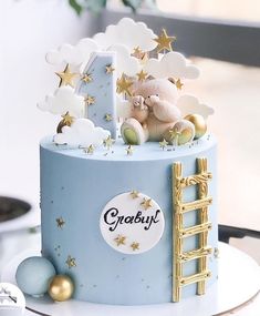 there is a blue cake with gold stars on it and a teddy bear in the top