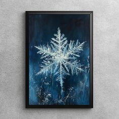 a painting of a snowflake in blue and white on a gray wall next to a black frame