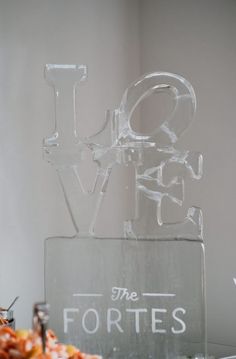 an ice sculpture that says love and the fortes is on top of a table