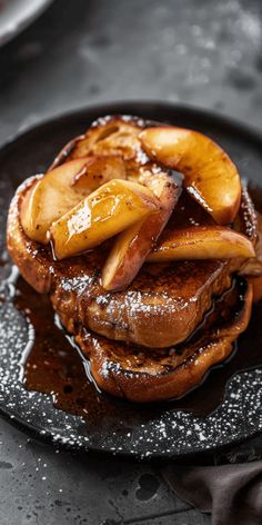 french toast with apple slices on top and syrup drizzled over the side