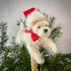 a white dog ornament hanging from a christmas tree