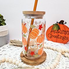 a glass jar with a wooden stick in it on a doily next to pumpkins