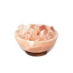 a bowl filled with pink crystals on top of a white table