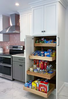 an open pantry in the middle of a kitchen with lots of food on shelves and drawers