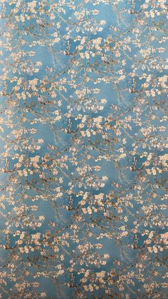 a blue and gold wallpaper with white flowers on the bottom, in an area that looks like it has been painted