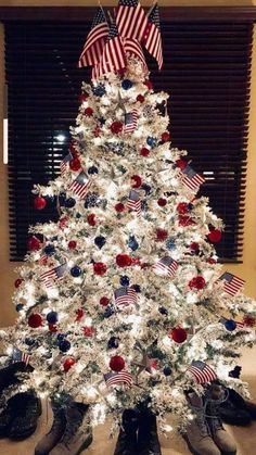 a white christmas tree decorated with red, white and blue decorations in the shape of an american flag