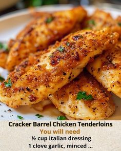 a white plate topped with chicken tenders on top of a table