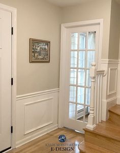 an empty entryway with white walls and wood flooring is seen in this image