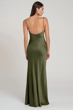 the back of a woman wearing a green dress with spaghetti straps and low neckline