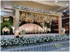 a wedding stage decorated with white flowers and greenery