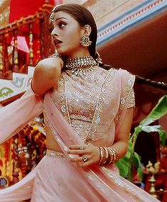 a woman in a pink dress standing next to stairs