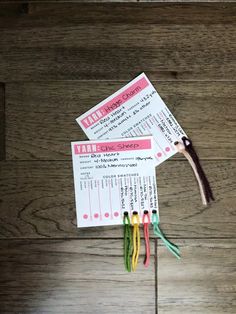 two tickets are sitting next to each other on a wooden table with toothbrushes