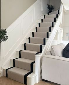 a white couch sitting next to a set of stairs