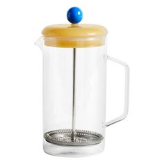 a glass french press coffee maker with a yellow lid and blue ball on the top