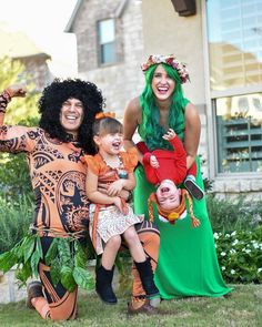 three people dressed in costumes posing for a photo with two children and one adult standing behind them