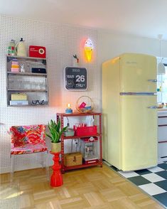 a yellow refrigerator sitting in the middle of a kitchen next to a black and white checkered floor