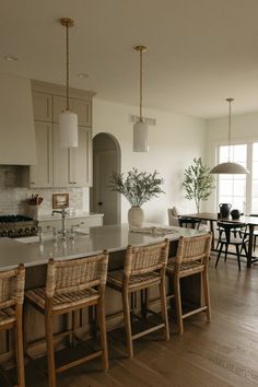 a kitchen filled with lots of counter top space and wooden chairs next to an island