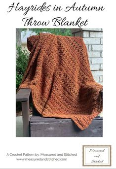 an orange crocheted blanket sitting on top of a wooden bench next to a brick wall