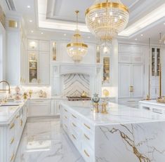 a large kitchen with marble counter tops and gold accents on the ceiling, along with white cabinets