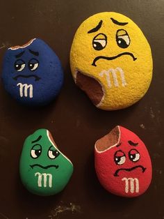 three rocks with different colored faces painted on them