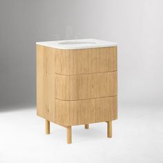 a white sink sitting on top of a wooden cabinet next to a gray wall and floor