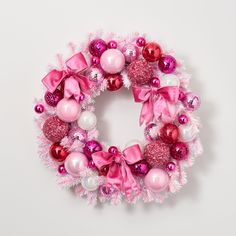 a pink and white christmas wreath with ornaments